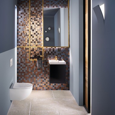 Mozaik arka panelin önünde Acanto asma klozet ve Acanto lavabo bulunan modern bir misafir banyosuna bakış